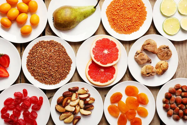 Different products on saucers on wooden table, top view — Stock Photo, Image