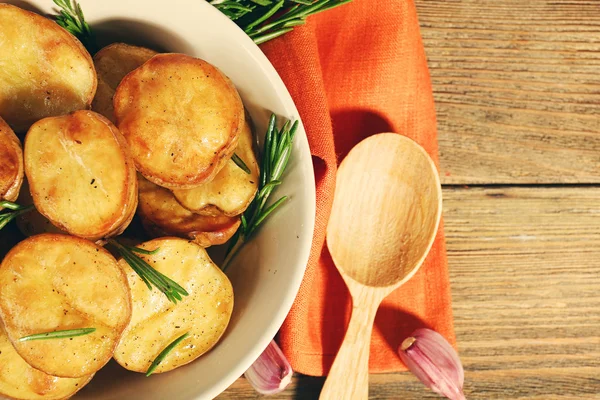 Deliziosa patata al forno con rosmarino in ciotola sul tavolo da vicino — Foto Stock