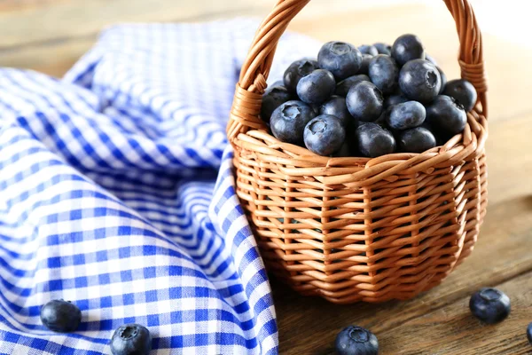 Läckra mogna blåbär i korgen på bordet på nära håll — Stockfoto