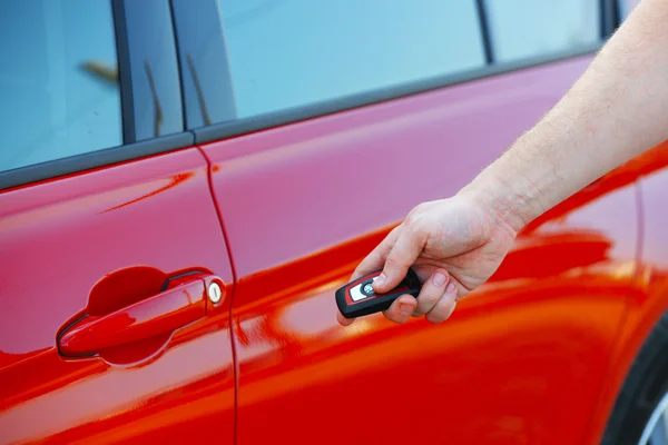 Pressing alarm button of red car — Stock Photo, Image