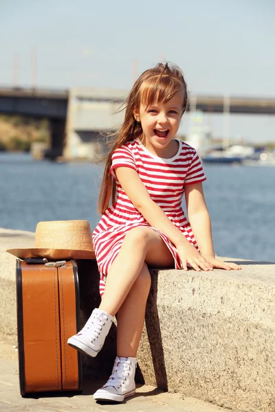 Klein meisje met koffer — Stockfoto