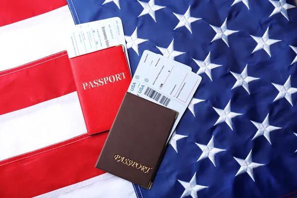 Passaportes, bilhetes deitados na bandeira americana — Fotografia de Stock