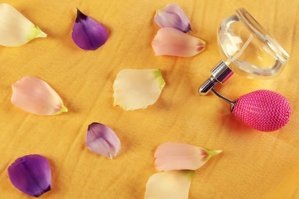 Botella de perfume y pétalos de rosa — Foto de Stock