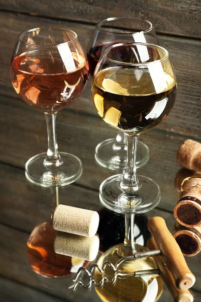 Wine glasses, corks and screw on wooden background — Stock Photo, Image