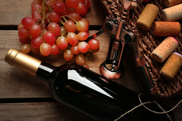 Botella de vino y uva sobre mesa de madera — Foto de Stock