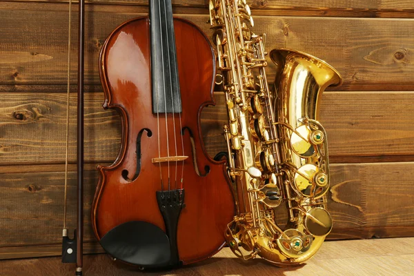 Violino e saxofone em fundo de madeira — Fotografia de Stock