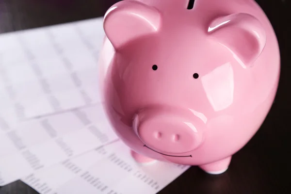 Pig moneybox and calculating equipment on desk closeup — Stock Photo, Image