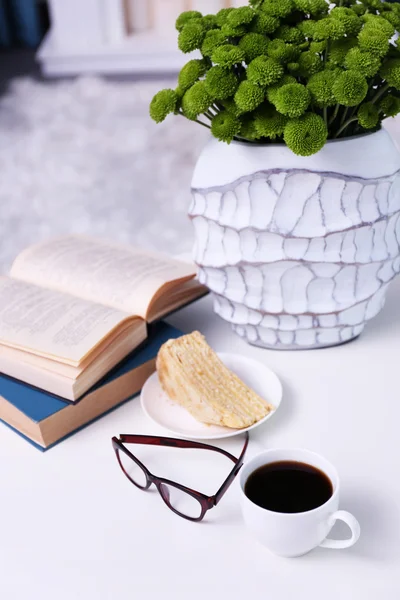 Xícara de café com livros na mesa no quarto — Fotografia de Stock