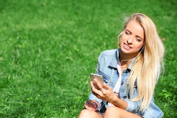 Donna con auricolari e smartphone — Foto Stock