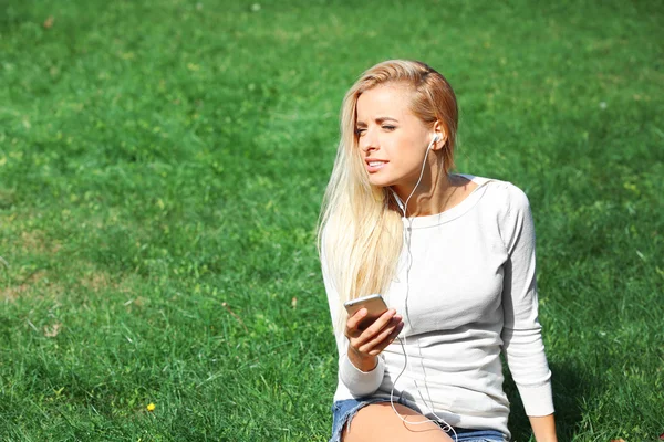 Женщина с наушниками и смартфоном — стоковое фото