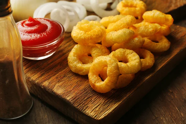 Pommes-Ringe mit Sauce und Zwiebeln auf Schneidebrett — Stockfoto