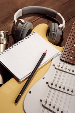 Elektro gitar ahşap arka plan üzerinde mikrofon ve kulaklık ile
