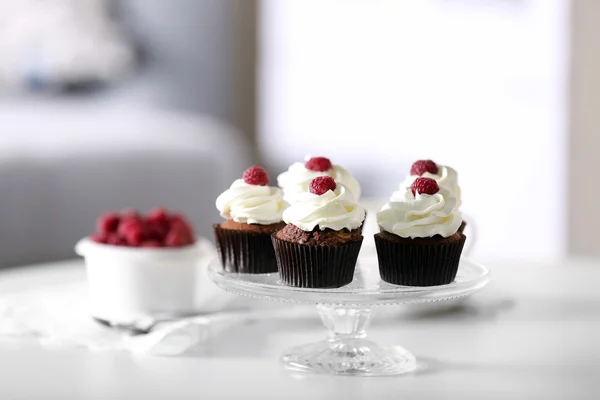 Gyönyörű csokoládé cupcakes tejszínnel és a málna, a táblázat — Stock Fotó