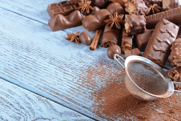 Doces de chocolate com pó sobre fundo de madeira — Fotografia de Stock