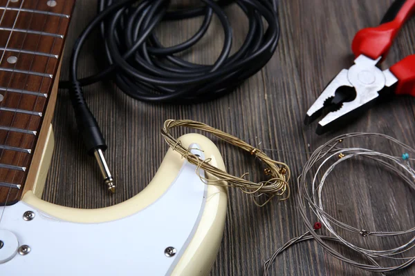 Chitarra elettrica con attrezzatura musicale su sfondo di legno — Foto Stock