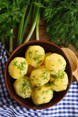 Masada bir kapta yeşillikleri ile haşlanmış patates yakın çekim