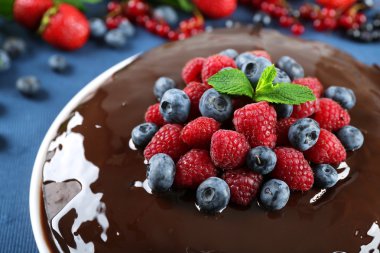 Mavi masa örtüsü, closeup üzerinde yaz meyveleri lezzetli çikolatalı kek