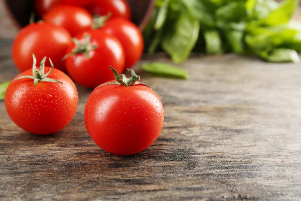 Kirschtomaten mit Basilikum auf Holztisch aus nächster Nähe — Stockfoto