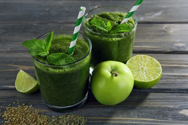 Succo sano verde con frutta ed erbe sul tavolo di legno da vicino — Foto Stock