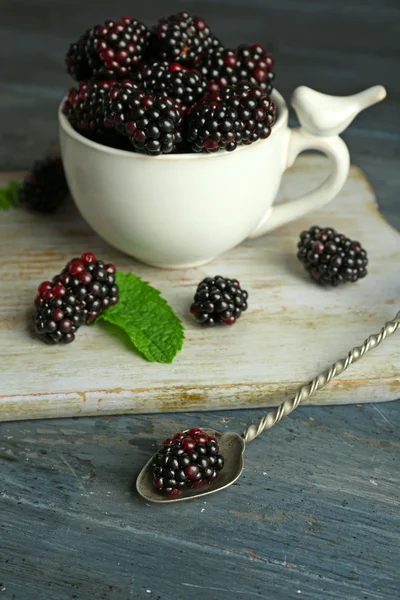 Un mucchio di more dolci con menta in tazza sul tavolo da vicino — Foto Stock