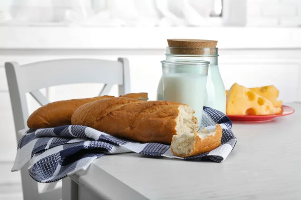 Milk with bread and cheese on table in kitchen — Stock Photo, Image