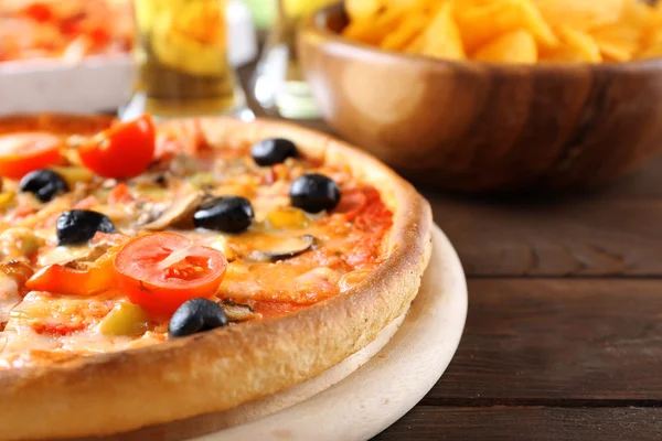 Pizza servida com cerveja na mesa de madeira — Fotografia de Stock