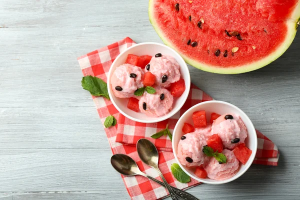 Gelato all'anguria in ciotole su sfondo di legno a colori — Foto Stock