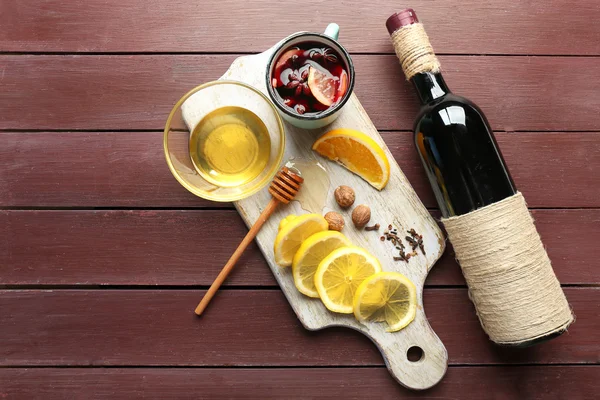 Tradiční svařené víno v hrnečku na dekorované dřevěné pozadí, zblízka — Stock fotografie