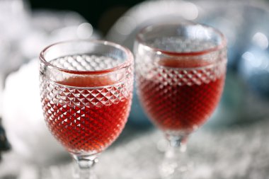 Karlı masada Noel süslemeleri ile şarap gözlük, yakın çekim