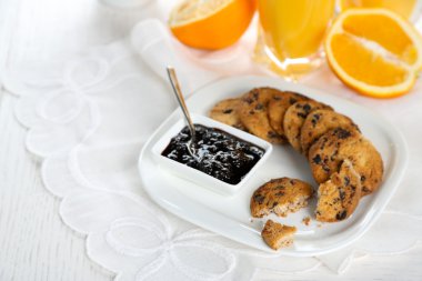 Tabak çikolata kırıntıları, reçel ve portakal beyaz masada ile lezzetli tatlılar