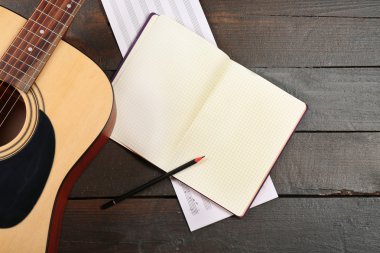 Ahşap arka plan üzerine gitar ve müzik yaprak