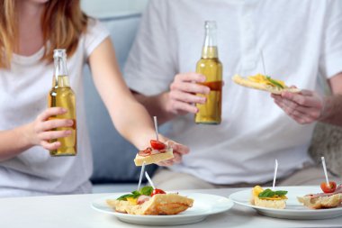 Arkadaşlar el ile şişe bira ve aperatifler, yakın çekim