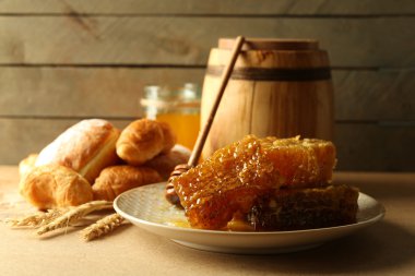 Plaka, peteğin sepeti ahşap arka plan üzerinde sıcak buns