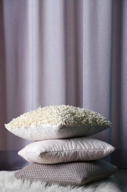 Bir odada bir halı üzerinde rengarenk yastıklar