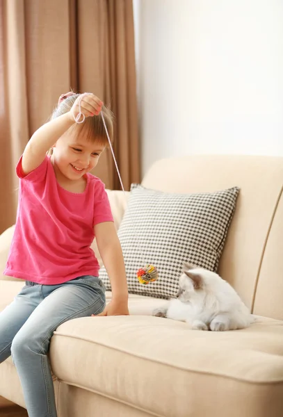 Söt flicka som leker med kattunge — Stockfoto