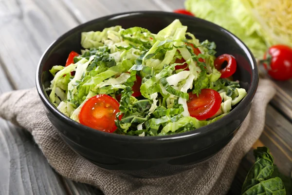 Savoy cabbage and tomato salad served in bowl on wooden table — Stock Photo, Image