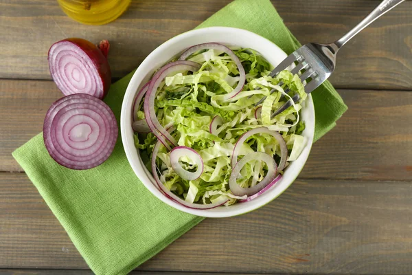 Savoy cabbage and onion salad served in bowl on wooden table — Stock Photo, Image