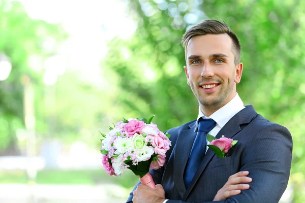 Groom holding wedding bouquet — Stock Photo, Image