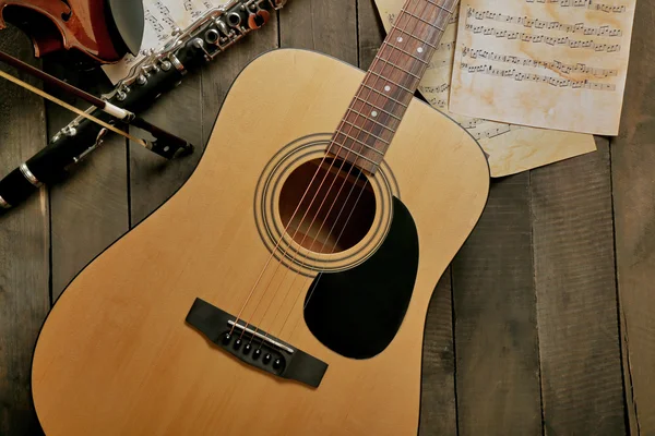 Guitarra acústica, saxofón soprano, violín, flauta y hojas de notas sobre fondo de madera —  Fotos de Stock