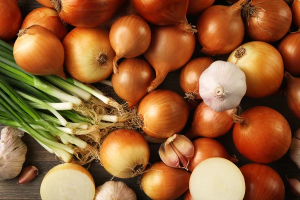 Fresh different onions with garlic on wooden background — Stock Photo, Image