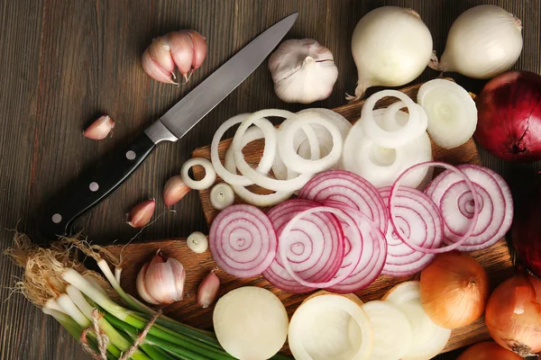 Samenstelling van de uien en knoflook op houten achtergrond — Stockfoto