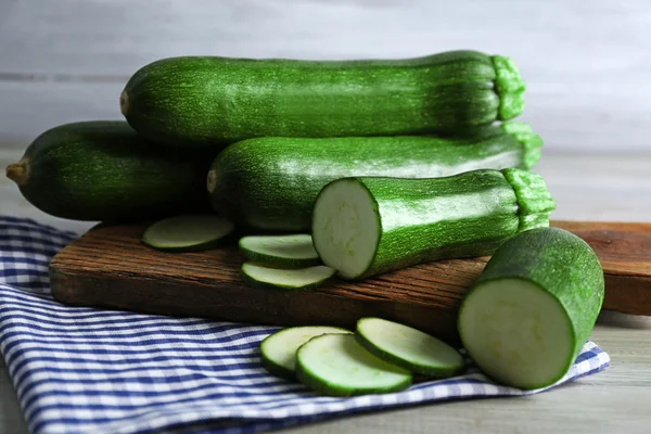 Fresh sliced zucchini on cutting board, on wooden background — Stock Photo, Image