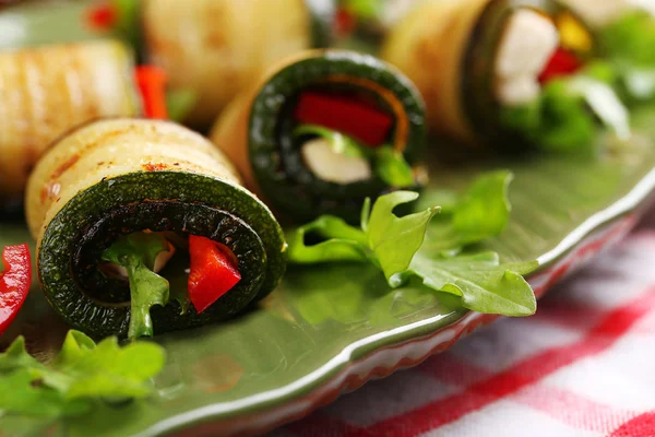 Rollos de calabacín con queso, pimientos y rúcula en el plato, primer plano — Foto de Stock