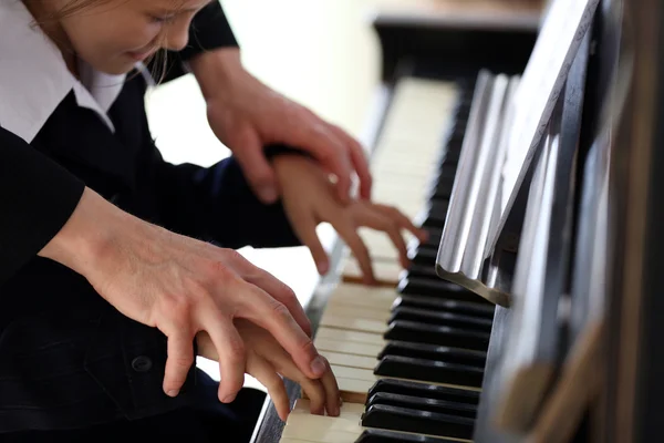 Professeur trains pour jouer piano fille — Photo