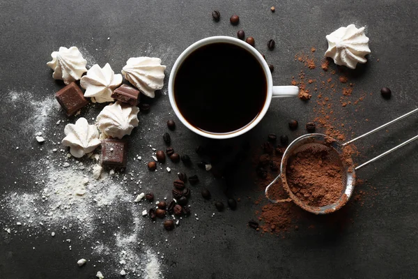 Taza de café y dulces sobre fondo negro de madera — Foto de Stock