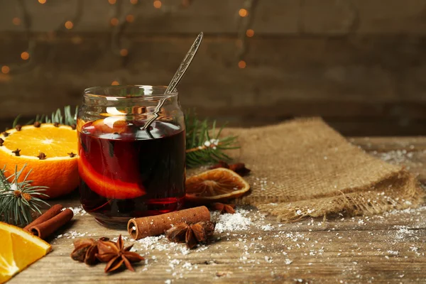 Glühwein in Glasbank auf dekoriertem Holztisch — Stockfoto