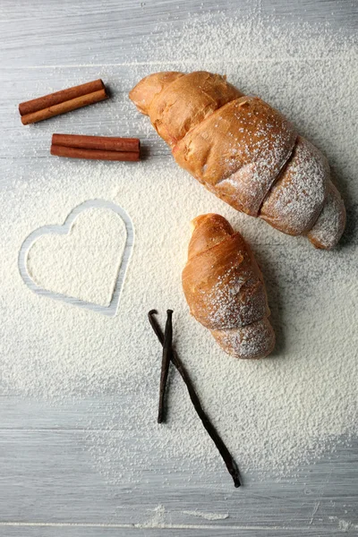 Corazón de harina, croissant y especias sobre fondo gris — Foto de Stock