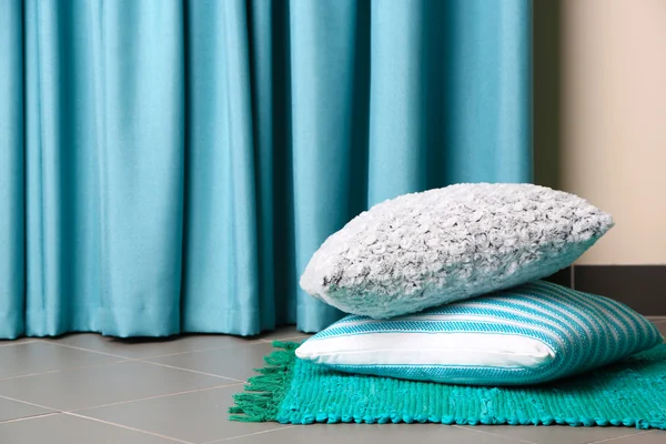 Multicoloured pillows on a carpet in a room — Stock Photo, Image