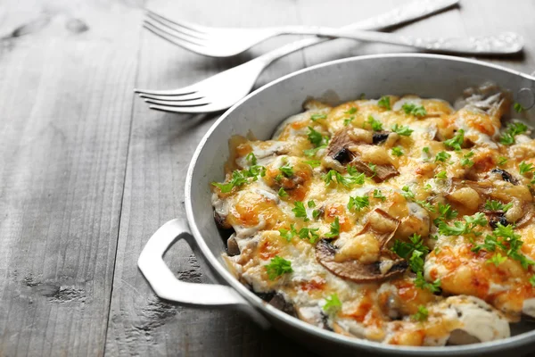 Roasted mushrooms, chicken and cheese gratin in pan, on wooden background — Stock Photo, Image