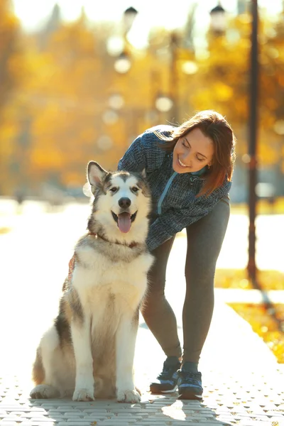 Женщина гуляет с собакой в парке — стоковое фото